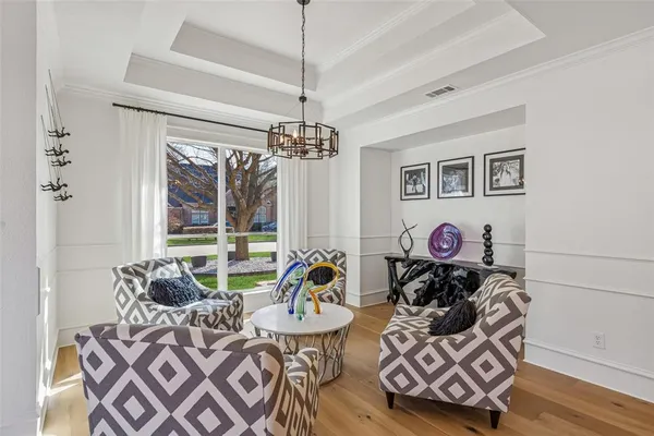 a living room with furniture a chandelier and a window