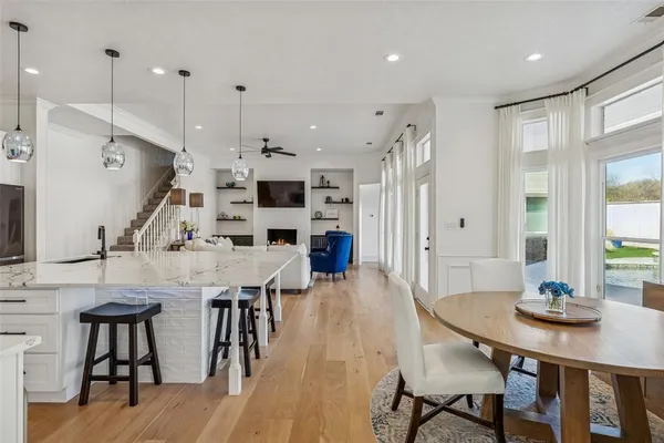 a view of a dining room and livingroom with furniture wooden floor a chandelier