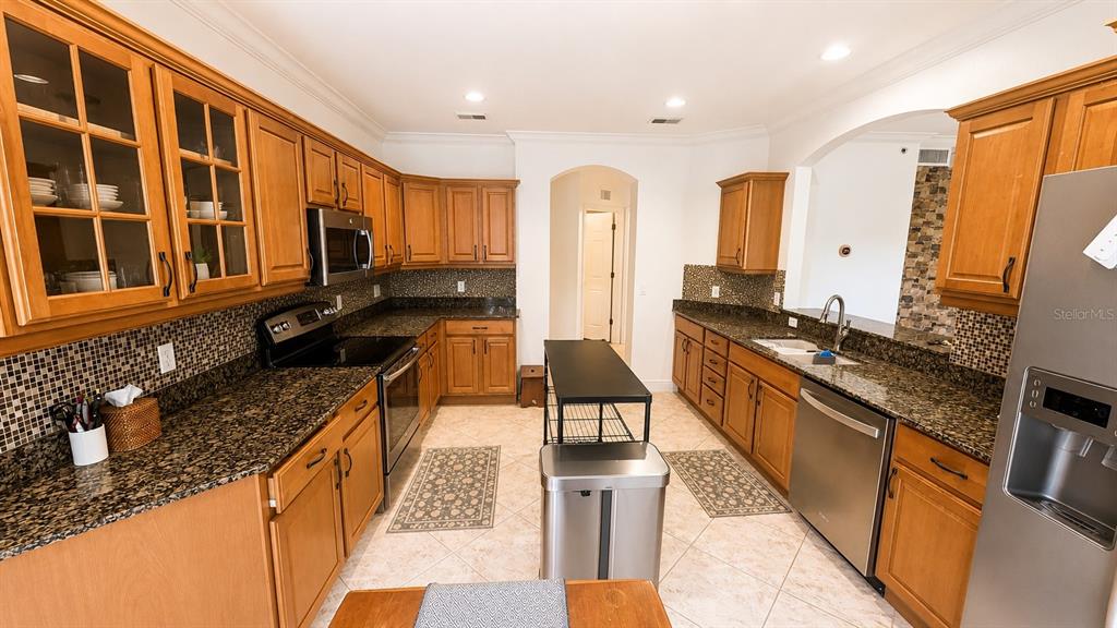 6552 Moorings Point Circle, Unit 102 Lakewood Ranch, FL 34202 - Photo 9 of 57 a kitchen with stainless steel appliances granite countertop a sink stove and cabinets