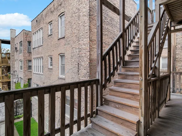 a view of a balcony with wooden fence and stairs