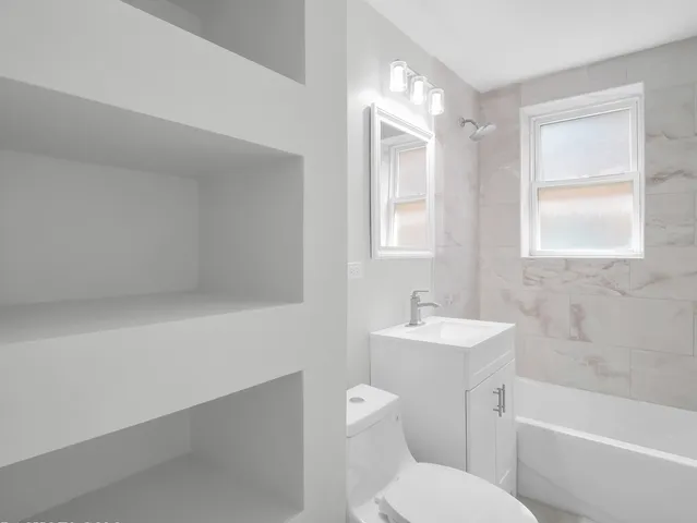 a bathroom with a sink toilet vanity and bathtub