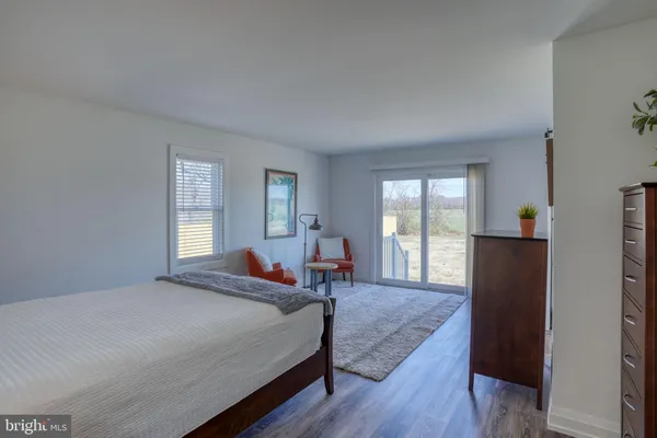a bedroom with a bed and a lamp on dresser