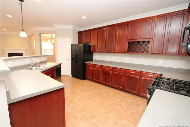 a kitchen with stainless steel appliances granite countertop wooden cabinets a stove a sink and a refrigerator