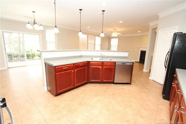 a kitchen with stainless steel appliances granite countertop a sink a counter space and a view of living room