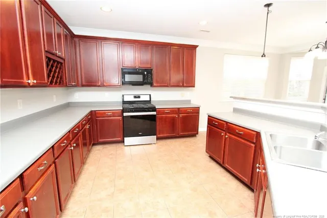 a kitchen with stainless steel appliances granite countertop wooden cabinets a stove top oven a sink and dishwasher