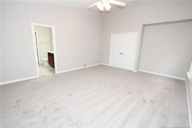 an empty room with a chandelier fan