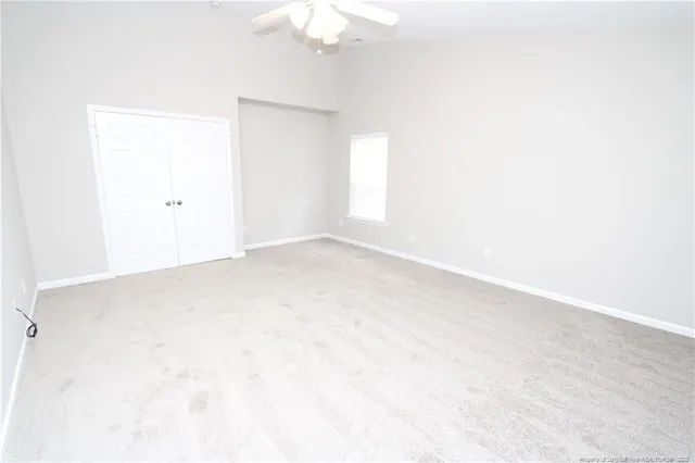 an empty room with a chandelier fan