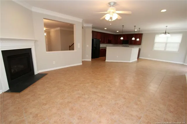 a view of an empty room with a fireplace and a window