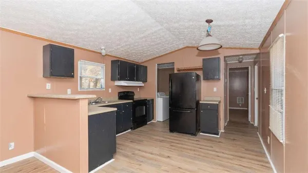 a kitchen with stainless steel appliances granite countertop a refrigerator a stove top oven a sink dishwasher and wooden cabinets