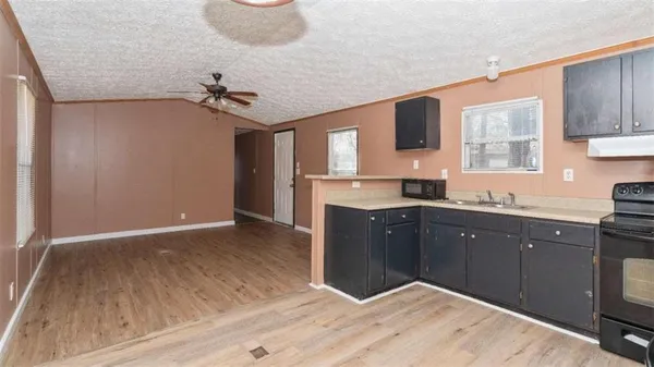 a kitchen with kitchen island granite countertop wooden cabinets and a sink
