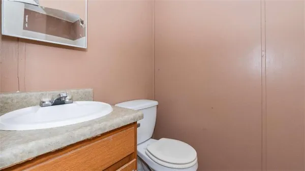 a bathroom with a granite countertop toilet and sink
