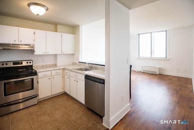 49 Day Street, Unit 404 Norwalk, CT 06854 - Photo 4 of 11 a kitchen with granite countertop white cabinets and white appliances
