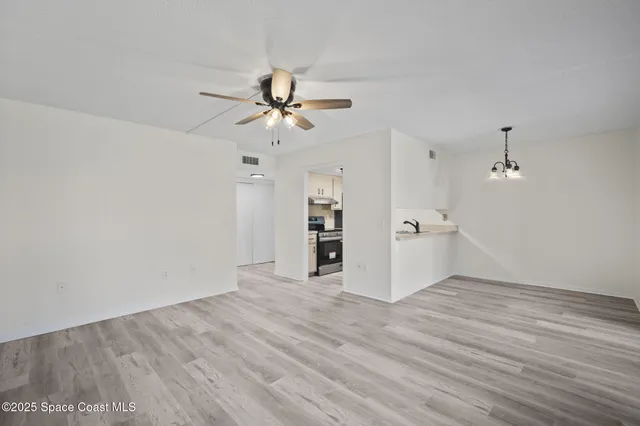 a view of a kitchen with wooden floor and a ceiling fan