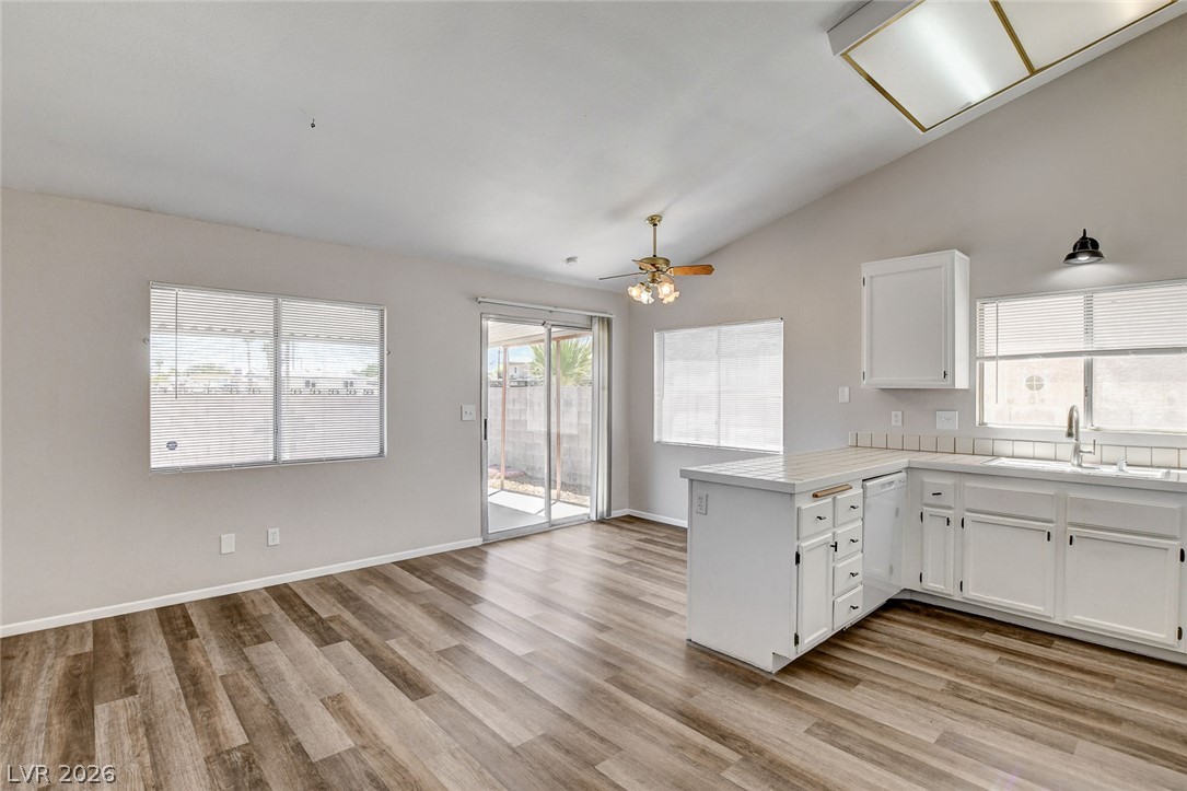6209 Warm River Road Las Vegas, NV 89108 - Photo 15 of 39 A well-lit kitchen with sleek wooden floors and a spacious dining area awaits.