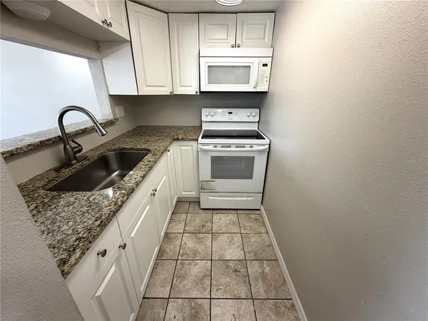 a kitchen with a sink a stove and cabinets