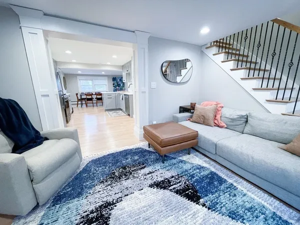 a living room with furniture a rug and white walls
