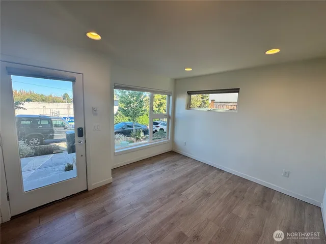 an empty room with wooden floor and windows