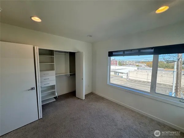 a view of an empty room with a window and bathroom