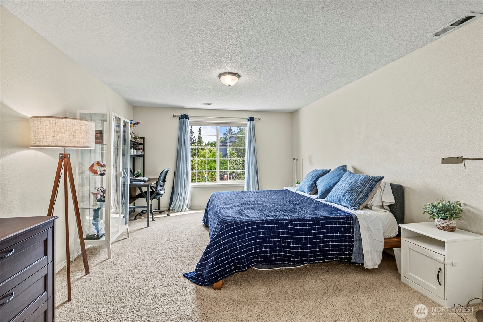 2410 North Heron Drive Ridgefield, WA 98642 - Photo 19 of 40 a bed sitting in a bedroom next to a window with tv and a large window