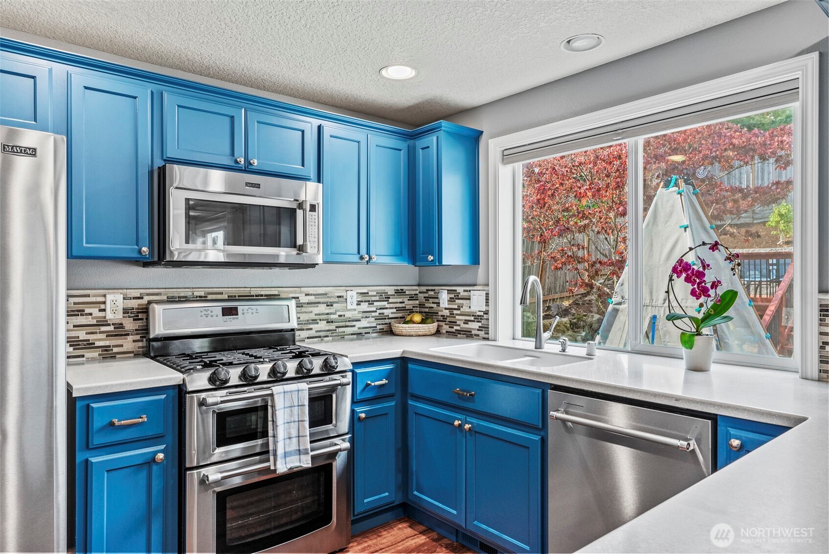 2410 North Heron Drive Ridgefield, WA 98642 - Photo 8 of 40 a kitchen with stainless steel appliances wooden cabinets and a stove top oven