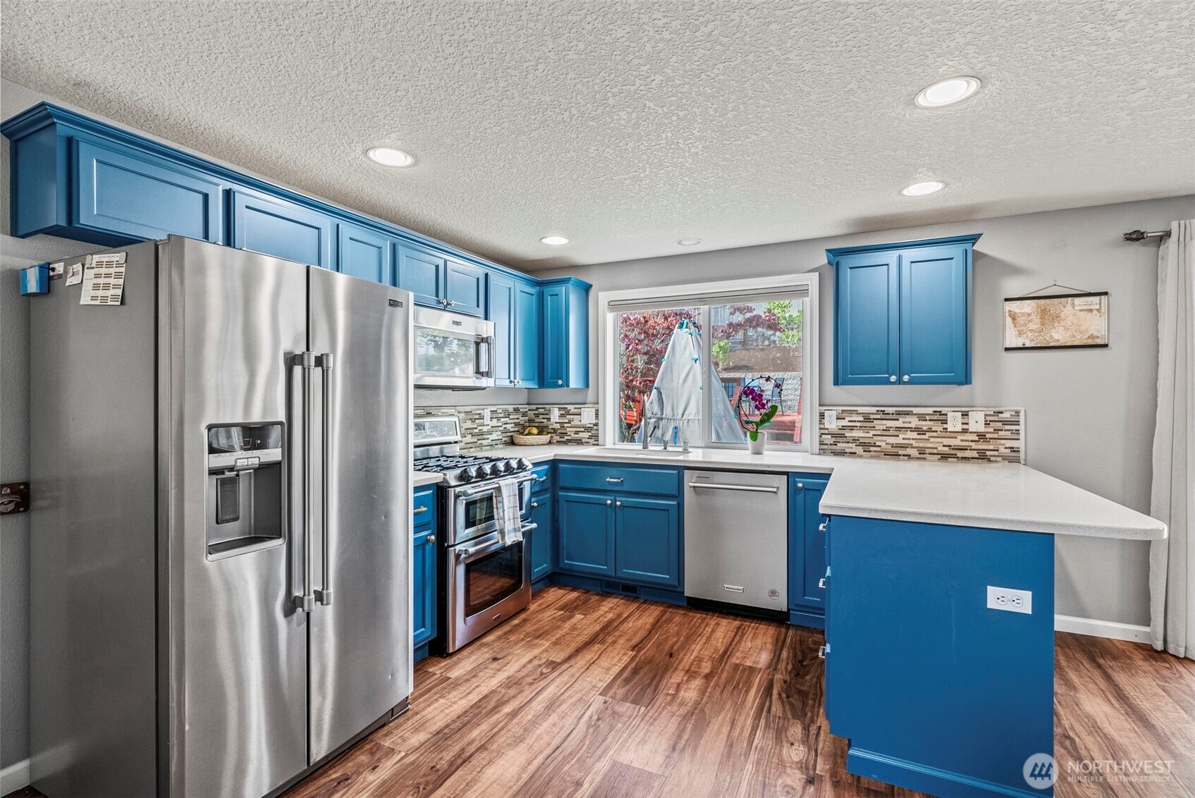 2410 North Heron Drive Ridgefield, WA 98642 - Photo 9 of 40 a kitchen with granite countertop a refrigerator stove top oven and sink