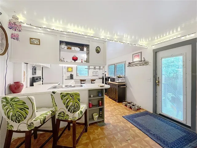 a living room with kitchen island granite countertop furniture and a chandelier