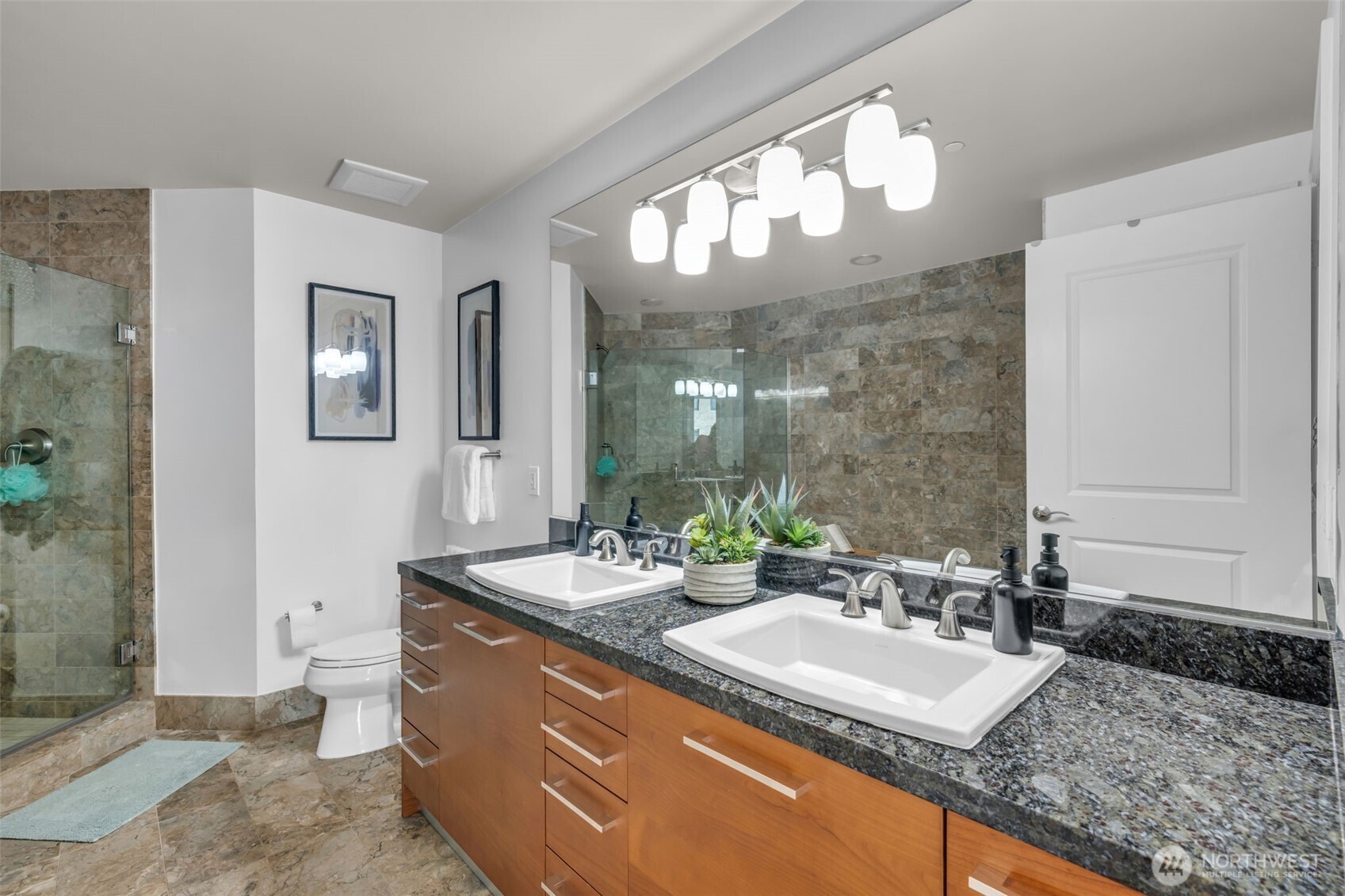 1920 4th Avenue, Unit 602 Seattle, WA 98101 - Photo 22 of 35 a bathroom with a granite countertop sink a large mirror and a shower