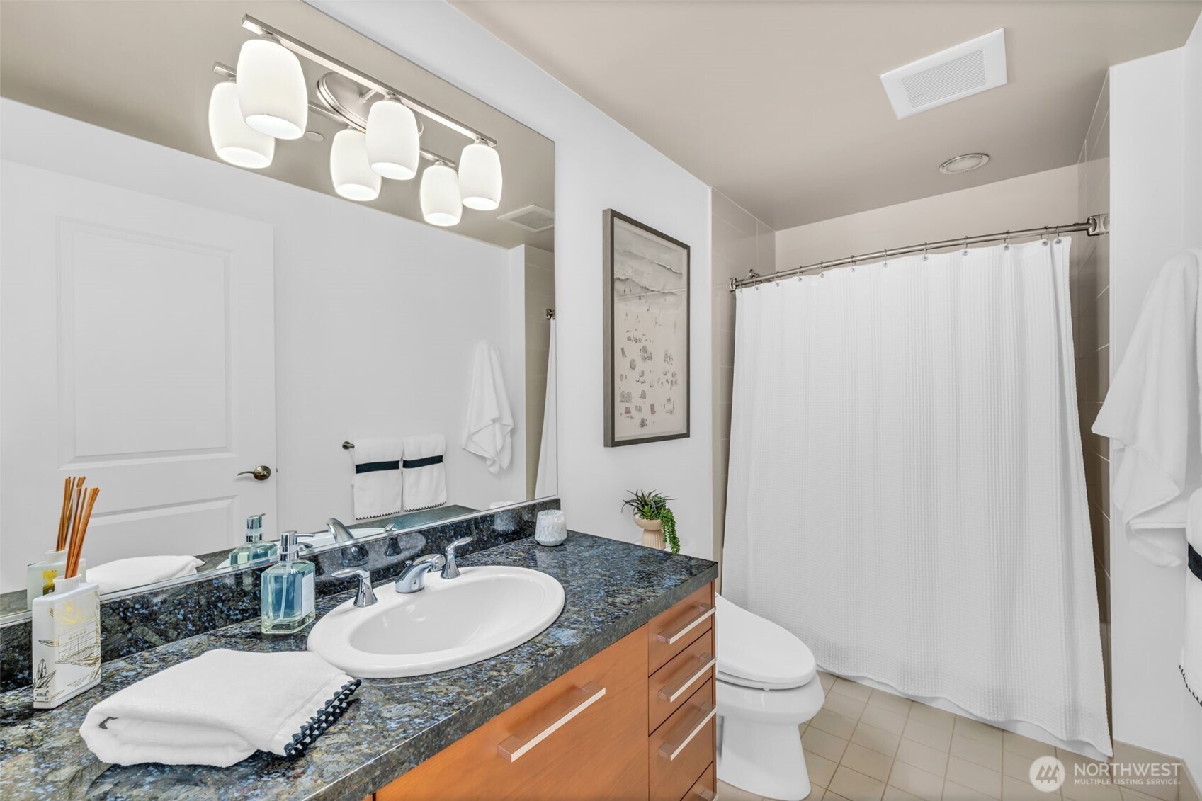 1920 4th Avenue, Unit 602 Seattle, WA 98101 - Photo 26 of 35 a bathroom with a granite countertop sink and a mirror with toilet