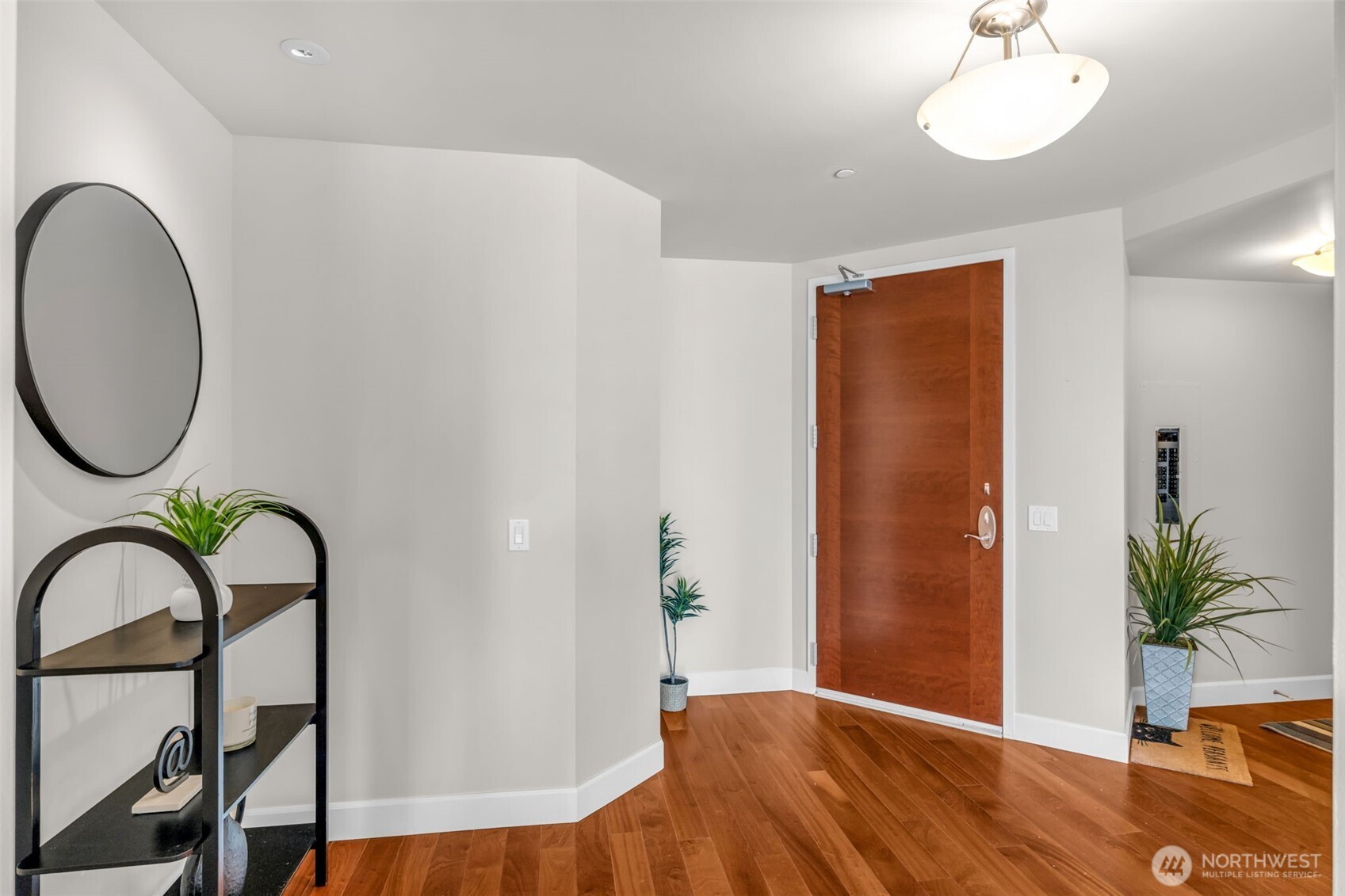 1920 4th Avenue, Unit 602 Seattle, WA 98101 - Photo 3 of 35 a view of a room with a potted plant and wooden floor