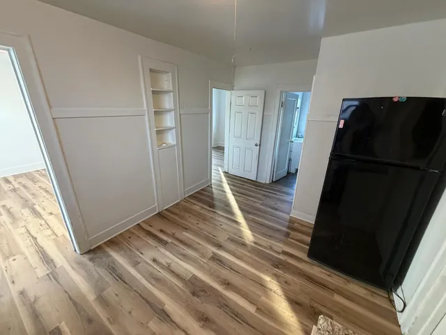 a view of a closet area with wooden floor and cabinet