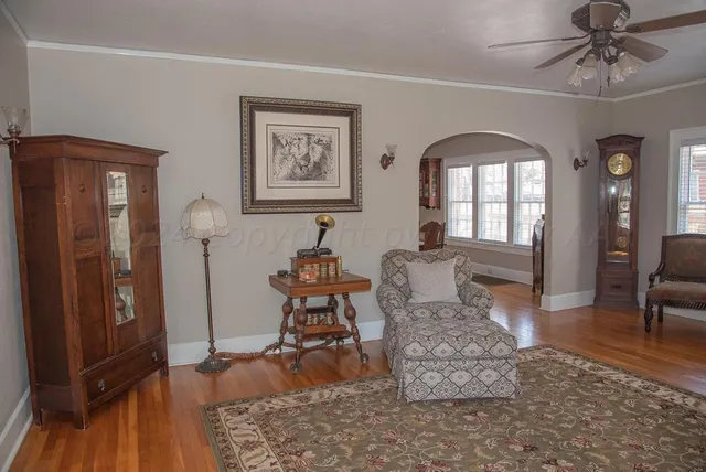 a view of a hallway with wooden floor and a chandelier