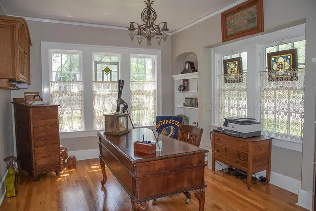a living room with fireplace furniture and a large window