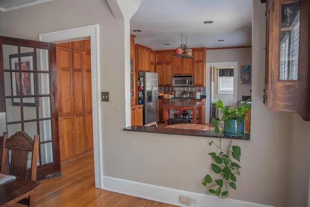 a view of a hallway with wooden floor and chandelier