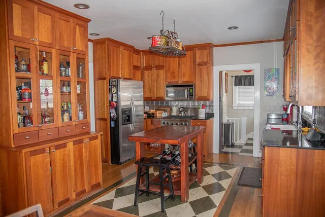 a view of an empty room with wooden floor and cabinet