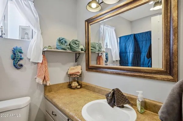 a bathroom with a granite countertop sink and a mirror