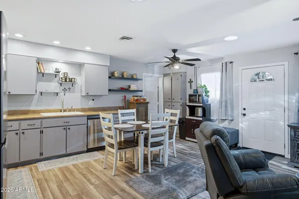 a kitchen with kitchen island a dining table chairs stainless steel appliances and cabinets
