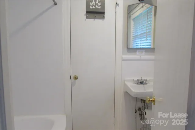a bathroom with a sink a shower and a mirror
