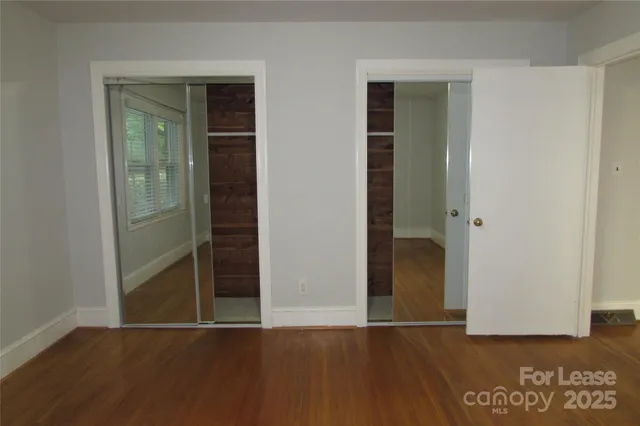 an empty room with wooden floor and closet