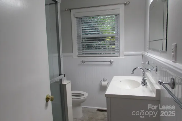 a bathroom with a sink a toilet and a window