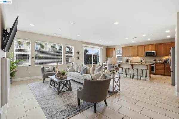 a living room with furniture and a view of kitchen