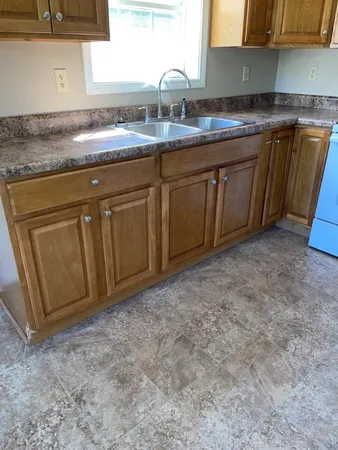a kitchen with granite countertop a sink and cabinets