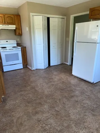 a view of a refrigerator in kitchen and a sink