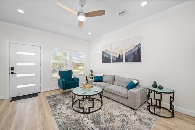a living room with furniture and a wooden floor