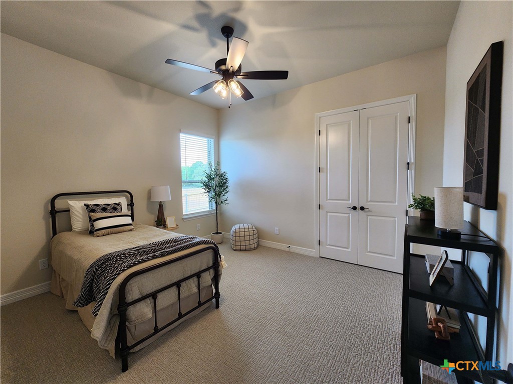 301 Rodeo Road Salado, TX 76571 - Photo 44 of 48 a spacious bedroom with a bed a couch and a chandelier