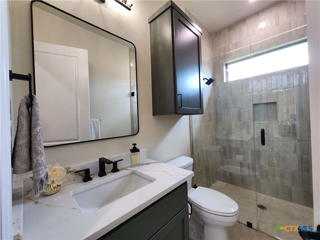 301 Rodeo Road Salado, TX 76571 - Photo 46 of 48 a bathroom with a granite countertop sink toilet and shower
