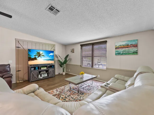 a living room with furniture a rug and a flat screen tv