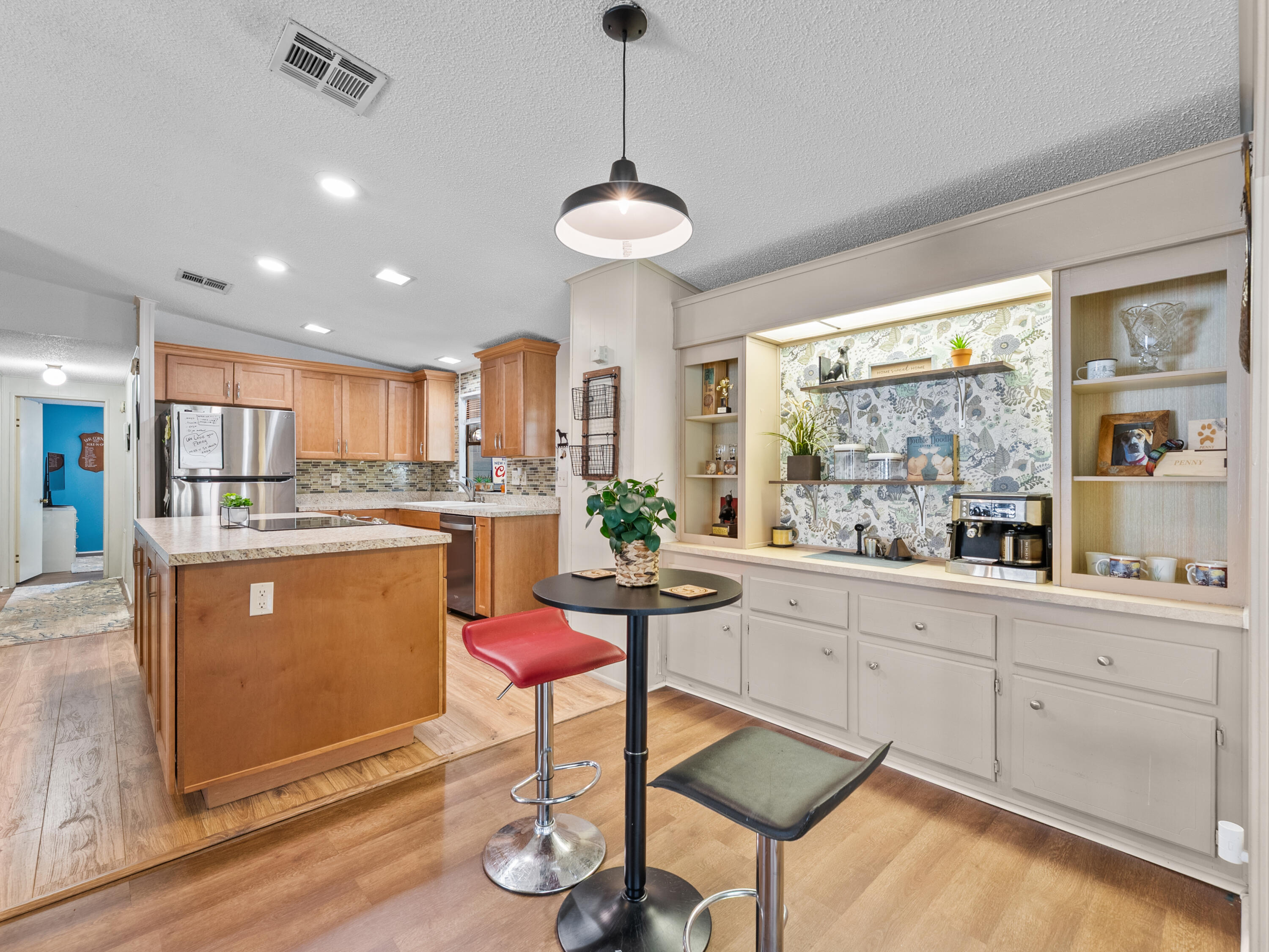 2855 Southwest Monarch Trail Stuart, FL 34997 - Photo 5 of 37 a kitchen with stainless steel appliances granite countertop a stove a sink a refrigerator and white cabinets with wooden floor