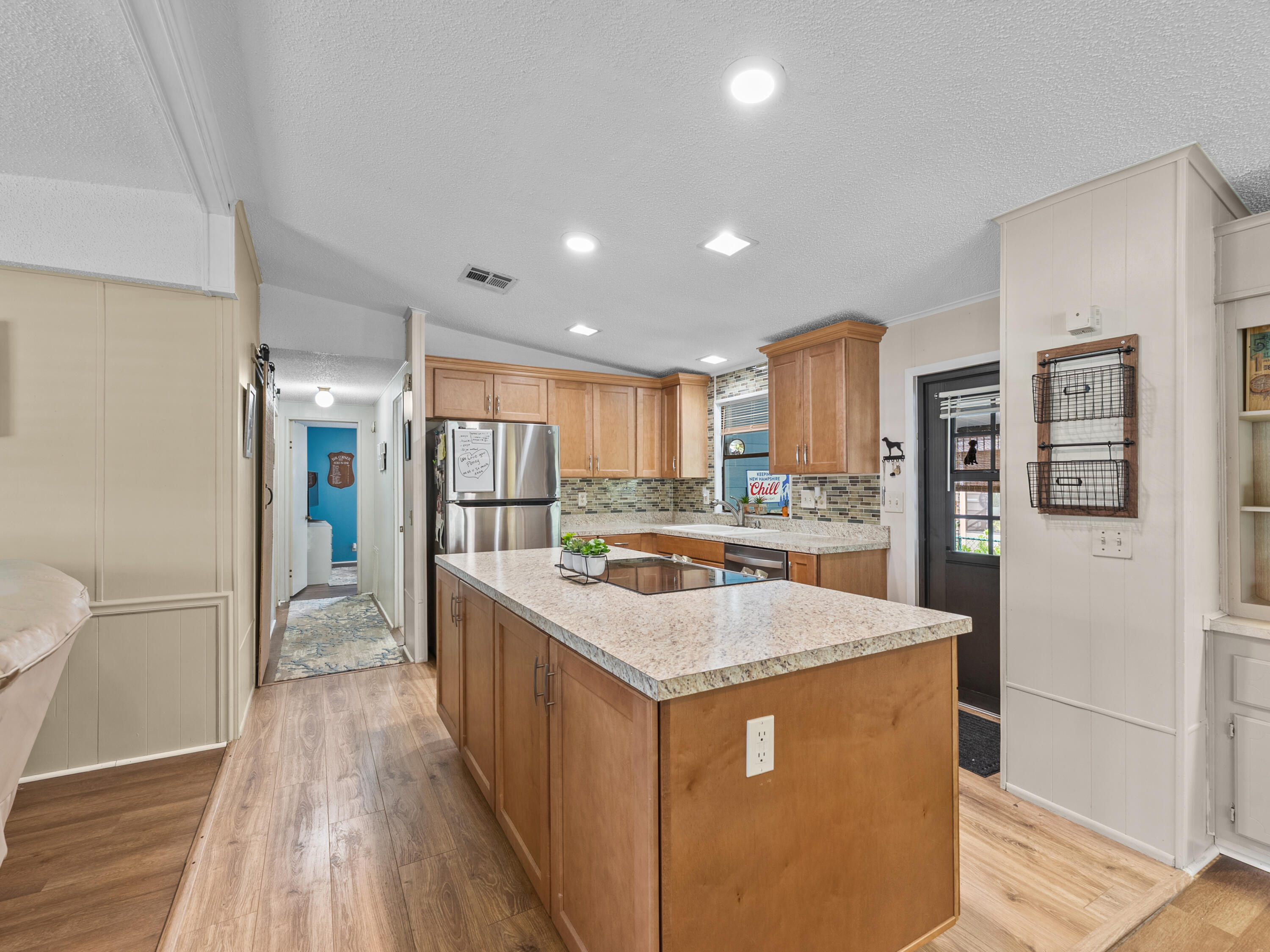 2855 Southwest Monarch Trail Stuart, FL 34997 - Photo 10 of 37 a kitchen with stainless steel appliances granite countertop a refrigerator a sink dishwasher and a stove with wooden floor