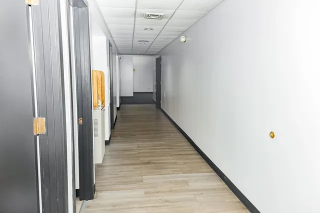 a view of a hallway with wooden floor and entryway