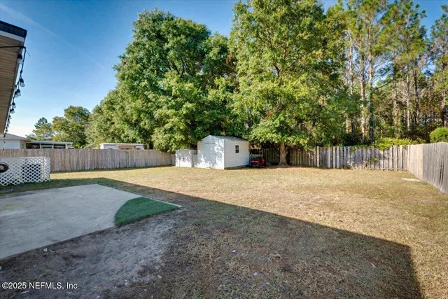 a backyard of a house with a tree and fence
